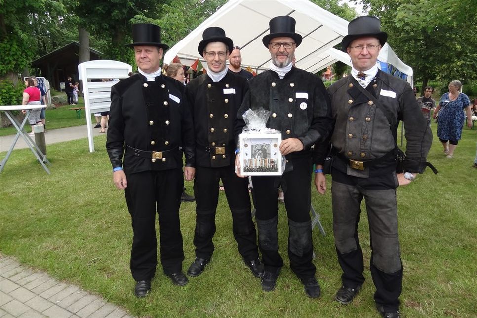 Vier Schornsteinfeger überbrachten eine Geldspende, für die sie unter allen Schornsteinfegern Ostholsteins gesammelt hatten.