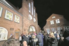 Viele Gäste verfolgen die feierliche Öffnung der ersten Adventsfenster am historischen Kremper Tor.