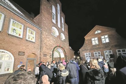 Viele Gäste verfolgen die feierliche Öffnung der ersten Adventsfenster am historischen Kremper Tor.