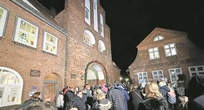 Viele Gäste verfolgen die feierliche Öffnung der ersten Adventsfenster am historischen Kremper Tor.