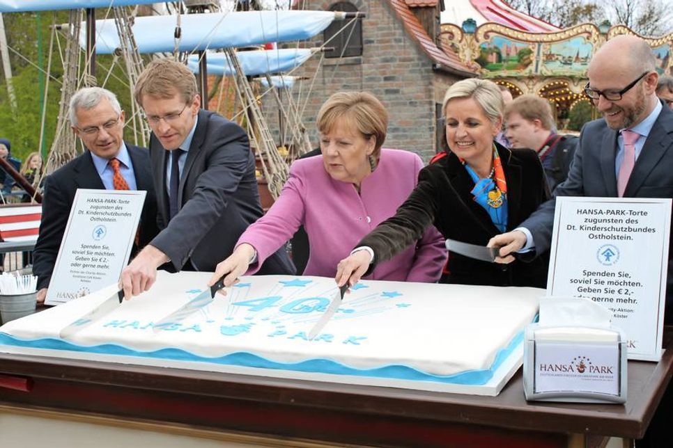 Tortenanschnitt: Andreas Leicht, Daniel Günther, Angela Merkel, Claudia Leicht und Peter Tauber setzten gekonnt das Messer an. Die Stücke wurden zugunsten des Deutschen Kinderschutzbundes Kreisverband Ostholstein verkauft.