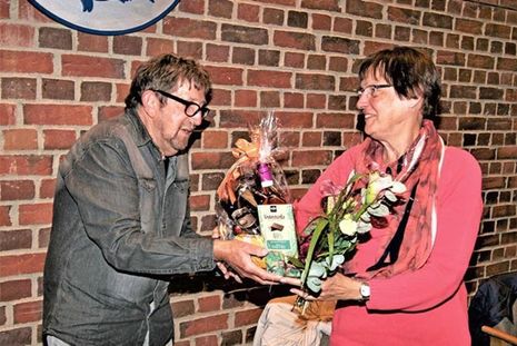 Gerhard Schöler überreicht Traute Weindl ein Präsent und Blumen als Dank für die gute Zusammenarbeit.