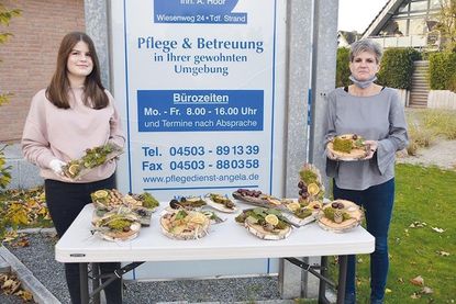 Die zwölfjährige Schülerin Paulina Sikoudis überreicht die selbstgebastelten Herbstgestecke an Adele Hoor, Inhaberin von „Pflegedienst Angela“. Diese werden von den Mitarbeiterinnen an die Kunden übergeben.