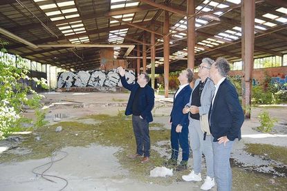 Diese Halle soll erhalten bleiben und später ohne Dach das Entrée zum neuen Ortsmittelpunkt bilden: Architekt Christian Erxleben (v.l.) erklärt Investor Dennis Romeiser, Bürgermeister Andreas Zimmermann und Dipl.-Ing. Stadtplaner Karsten Schwormstede Details.