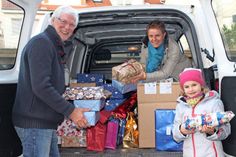 Uwe Muchow mit Kai-Anne Christensen und ihrer Tochter Lina beim Einladen der Geschenke am Verlagshaus des reporters.