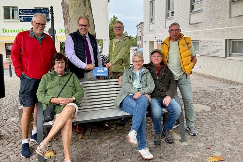Bürgermeister Mirko Spieckermann (3. v. lks.) und Projektvertreter Björn Streich (4. v. re.) brachten die Schnackbank-Plakette gemeinsam mit einer Urlaubergruppe aus Nordrhein-Westfalen an.