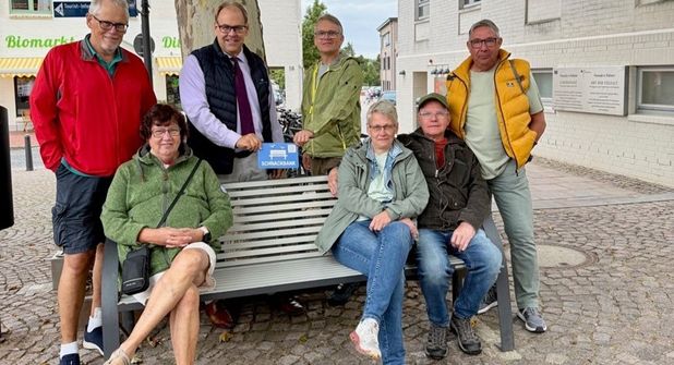 Bürgermeister Mirko Spieckermann (3. v. lks.) und Projektvertreter Björn Streich (4. v. re.) brachten die Schnackbank-Plakette gemeinsam mit einer Urlaubergruppe aus Nordrhein-Westfalen an.