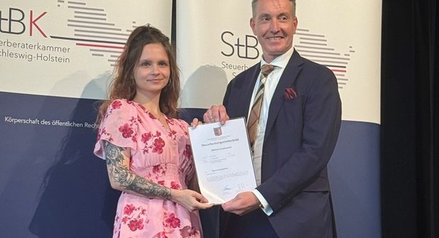 Wiktoria Stasinowski nimmt ihren Steuerfachangestelltenbrief entgegen.