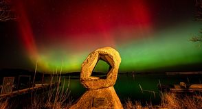 Polarlichter über dem Binnenwasser in Neustadt bilden einen surrealen Hintergrund für die Skulptur „Durchbruch“.