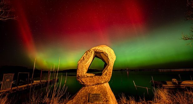 Polarlichter über dem Binnenwasser in Neustadt bilden einen surrealen Hintergrund für die Skulptur „Durchbruch“. (Foto: Jürgen Brunck)