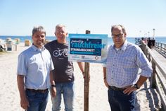 Links von der Seebrücke soll in Zukunft auf einem Abschnitt von circa 150 Metern nicht mehr geraucht werden, auf freiwilliger Basis. Stephan Reil vom Tourismus-Service, Ortsbeiratsvorsitzender Lars Prigge und Bürgermeister Mirko Spieckermann (v. lks.) präsentierten die neu aufgestellten Schilder.