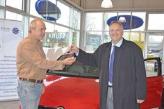 Freudestrahlend übergibt Sven Jessen die Autoschlüssel an Helmut Grimmig
