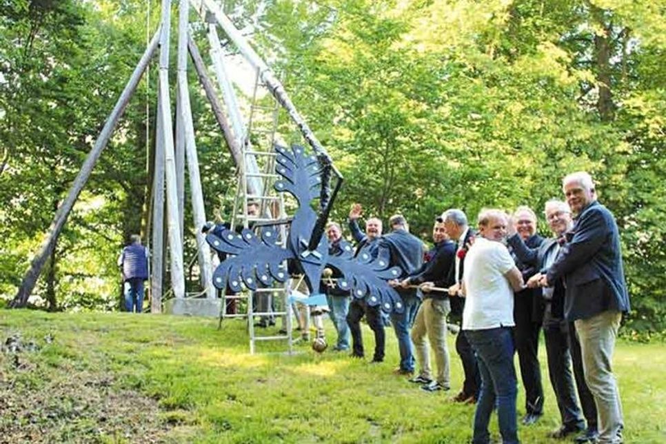 Mit vereinten Kräften wird der Holzvogel am Vortag an der Stange angebracht und aufgerichtet.