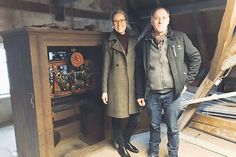 Judith Ohrtmann und Thomas Braun neben dem Uhrenkasten auf dem Dachboden des Amtsgerichts.