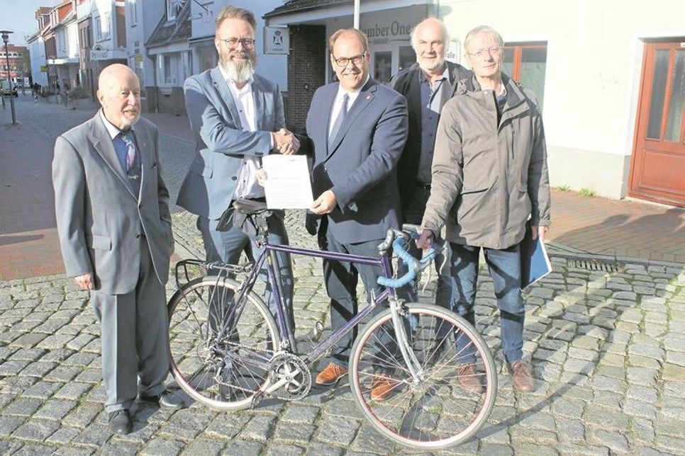 Geplant sind 160 Meter Oberflächenaustausch und die Einrichtung einer Fahrradstraße in der Hochtorstraße. Dort erfolgte die Übergabe des Förderbescheides mit Bürgervorsteher Sönke Sela, Verkehrsminister Claus Ruhe Madsen, Bürgermeister Mirko Spieckermann, Vorsitzender des Planungs-, Umwelt- und Bauausschusses Willy Heckel und Abteilungsleiter Eckhard Mittmann (v. lks.).