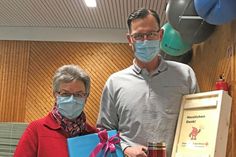 Birgit Dieckmann gratuliert Andreas Mösch im Namen des DRK-Ortsvereins Klausdorf mit einem Geschenk zur Jubiläumsspende.