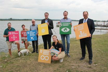 Nachhaltigkeitsmanagerin Lina Sophie Koop (vorne) freut sich gemeinsam mit den Fraktionsvorsitzenden Sebastian Kraatz (FDP), Margit Giszas (SPD), Clemens Reichert (BGN), Sebastian Schmidt (CDU) und Dr. Michael Böckenhauer Bündnis 90/Die Grünen) sowie Bürgermeister Mirko Spieckermann (v. lks.) über die neue Broschüre.