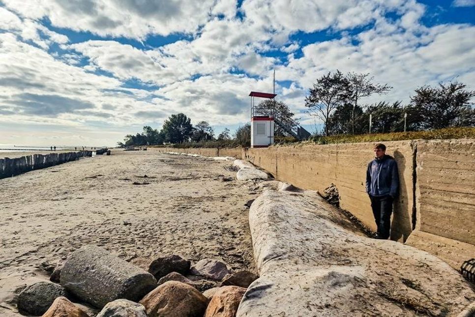 Am Südstrand kann man den Sandverlust besonders gut erkennen. Silas Grümmert vom Tourismus-Service ist weit über 1,80 Meter groß und reicht nicht ganz bis zur Uferschutzmauer.
