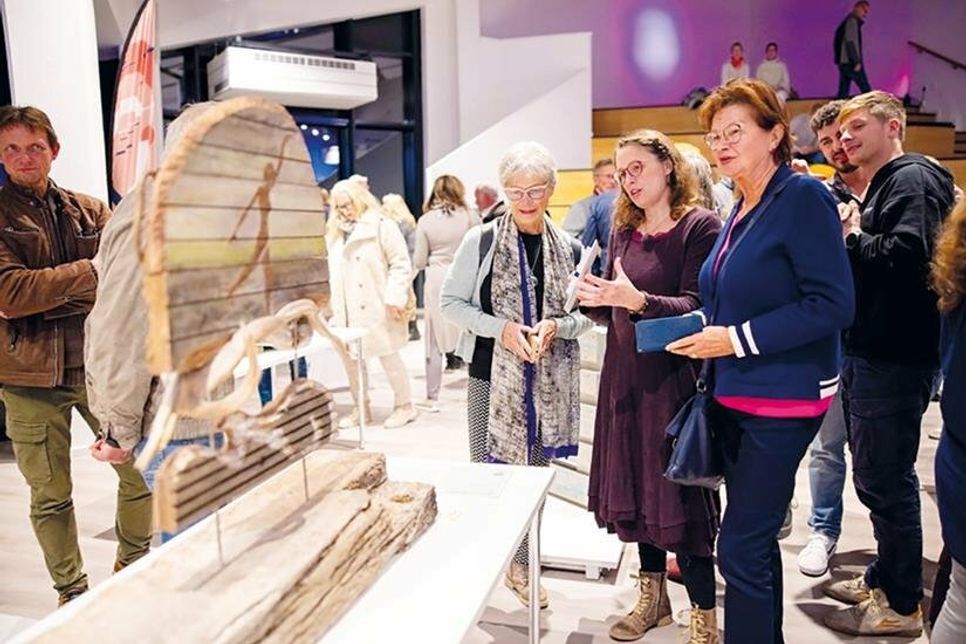 Austausch zwischen Besuchern und Künstlern bei der feierlichen Ausstellungseröffnung. Im Vordergrund das Sieger-Exponat.
