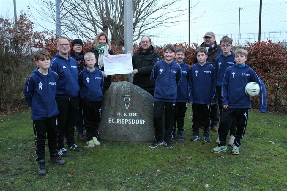 Spendenübergabe mit Jan Grimm (Mitte), Bürgermeister Hartwig Bendfeldt (3. v. re.), einer Jugendfußballmannschaft mit Trainer Marco Gau (2. v. lks.) sowie der 1. Vorsitzenden des Jugendfördervereins Sibylle Frank (3. v. lks.) und Kassenwartin Peggy Adeberg (5. v. lks.).