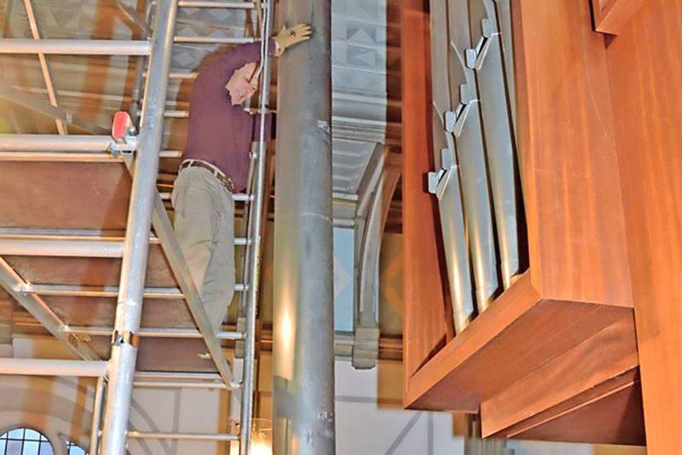 Die Orgelbauer Jan Martensen (Gerüst), Anja Sattler, Siegmund Teßmer und Kirchenmusiker Henrich Schwerk haben die schwere Basspfeife heil nach unten auf die Empore gebracht