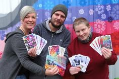 Das Projektteam mit Heike Rhein, Mark Mohns und Nina Nölting freuen sich über die bunten Postkarten.