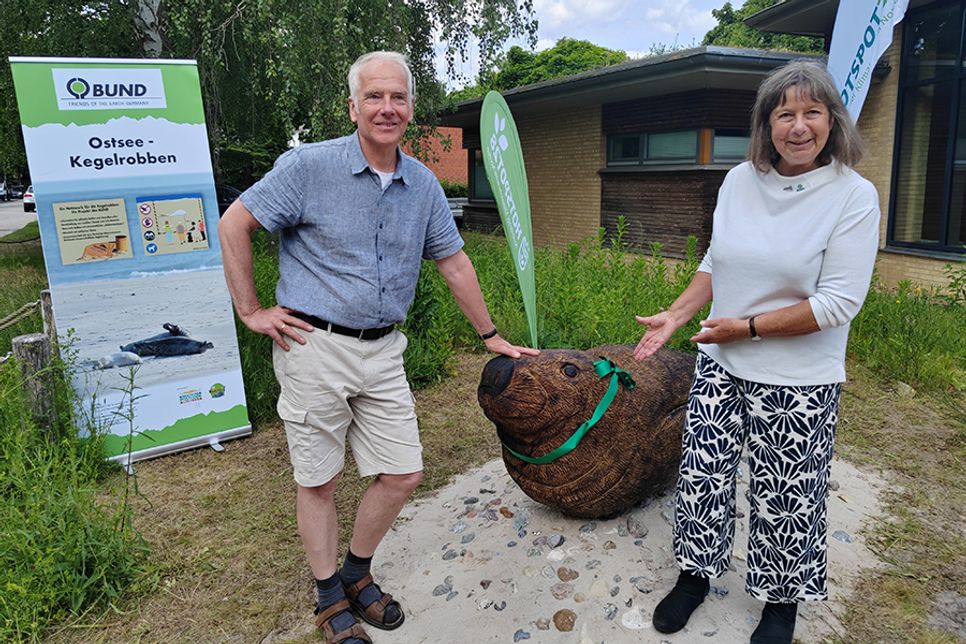 Nicola Boll vom BUND Mecklenburg-Vorpommern hat die lebensgroße Robbenskulptur aus Eichenholz an Matthias Braun vom Landschaftspflegeverein Dummersdorfer Ufer übergeben.