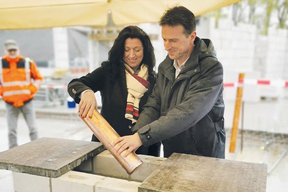 Feierliche Grundsteinlegung in Pönitz: Bürgermeisterin Bettina Schäfer und Schulleiter Wolfram Henkies legen die mit Dokumenten gefüllte Zeitkapsel in das Mauerwerk.