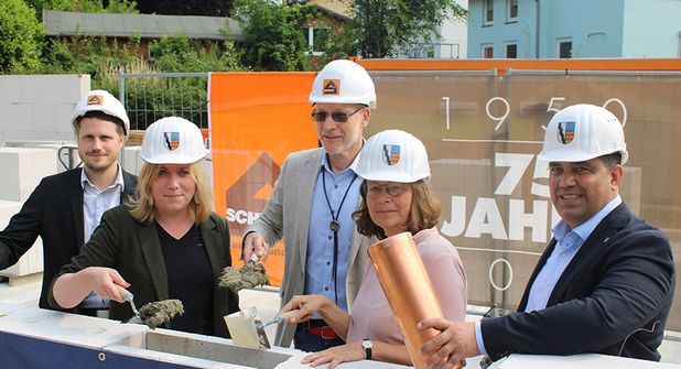 René Ratzmer (v.li.), stellvertretender Schulamtsleiter, Stadtpräsidentin Wiebke Zweig, Schulleiter Johannes Matlok, Bürgermeisterin Dr. Katrin Engeln und Bauamtsleiter Akbar Nassary vor dem „Versenken“ der Zeitkapsel.