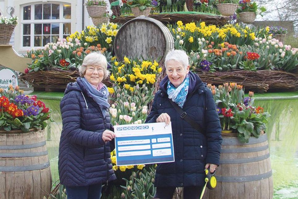 Scheckübergabe vor dem Blumenbrunnen in Timmendorfer Strand: Barbara Bergmann, Vorsitzende von Kinderherz e.V. (links), freut sich über die Spende von Monika Rocksin.