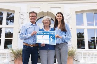 Tourismuschef Joachim Nitz und Cara Westphal, Projektleiterin des Kunstwettbewerbs der TSNT GmbH, bei der symbolischen Spendenscheckübergabe an Kinderherz-Vorsitzende Barbara Bergmann (Mitte).