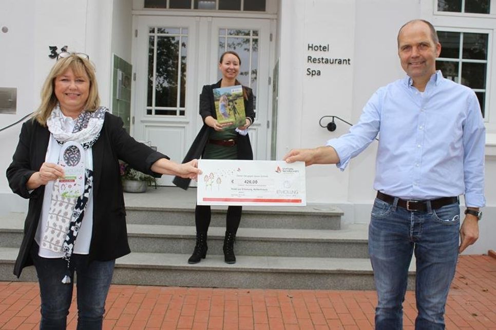 Sandra Redmann (lks.), Vorstandsvorsitzende der Stiftung Naturschutz Schleswig-Holstein, Hotelier Markus Schnoor und Julia Bünting vom Ostsee-Holstein-Tourismus bei der Übergabe der Spende.
