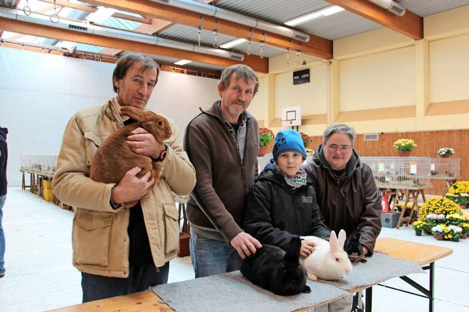 Vorsitzender des Kaninchenzüchtervereins U 31 Holger Jührs (2. v. lks.) mit Züchtern, Besuchern und den prämierten Rassekaninchen.