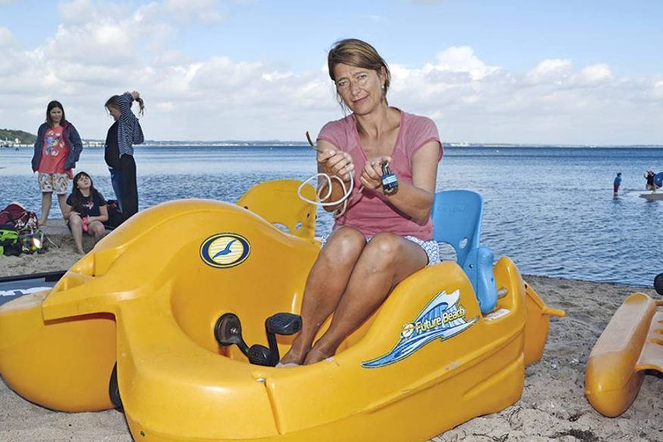 Strandkorbvermieterin Katja König auf einem ihrer geretteten Tretboote mit dem Drahtseil, das von Unbekannten aufgeschnitten wurde. (Foto: René Kleinschmidt)