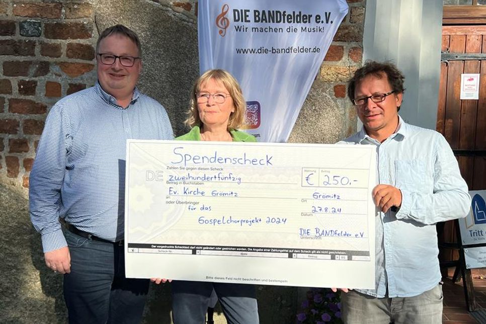 Olaf Wulf und Heike Liebstreich (v. lks.) übergeben die Spende an Kirchenmusiker Benjamin Gruchow.
