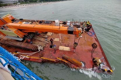 Blick von der neuen Seebrücke auf den gestrandeten Arbeitsponton, in dem Taucher versuchen, die beschädigten Kammern zu reparieren und leer zu pumpen. Zum Einstieg mit Taucherausrüstung musste extra das Deck großflächig per Schweißbrenner aufgeschnitten werden.