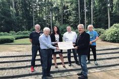 Scheckübergabe auf dem Cap Arcona Friedhof in Haffkrug-Neukoppel mit Michael Dietz (Dorfvorstand), Lutz Tamchina (Arbeitskreis 27. Januar), Bettina Schäfer (Bürgermeisterin), Helmut Kurth (Dorfvorsteher), Jürgen Schuhmacher und Jürgen Peters (Ostseesport Verein) (v. lks.).