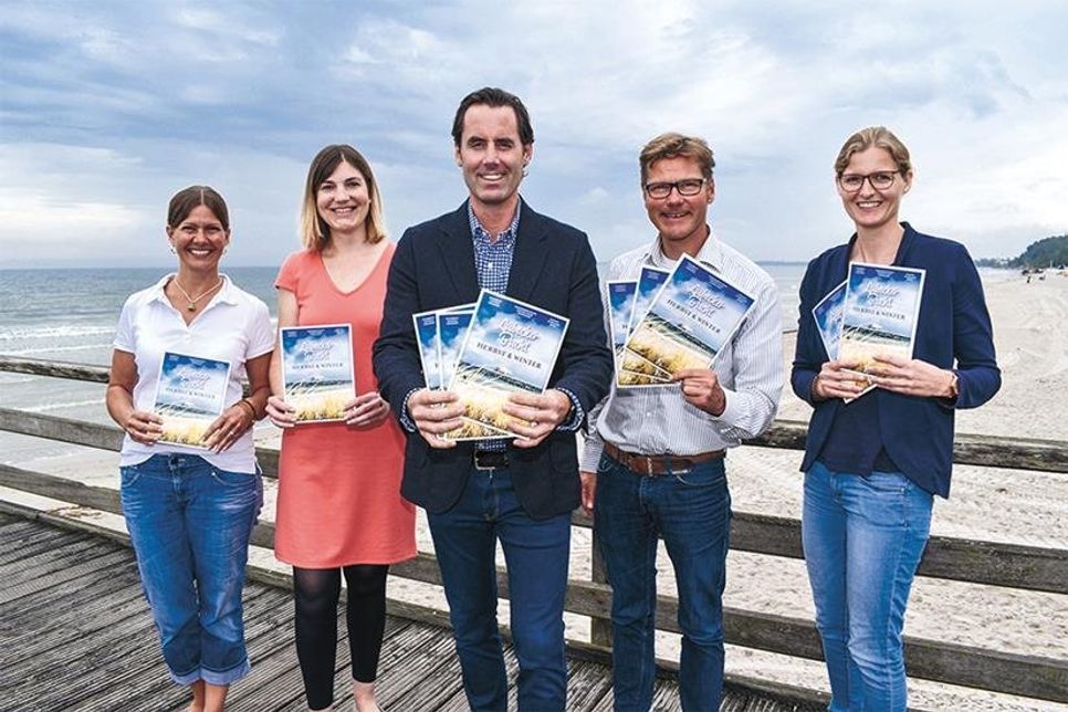Doris Wilmer-Huperz, Pressesprecherin Tourismus-Agentur Lübecker Bucht (von links), Sonja Wolpers, Leitung Produktmarketing TALB, Henrik Fels (ausführende Agentur), Joachim Nitz, Geschäftsführer Timmendorfer Strand Niendorf Tourismus GmbH, und Anja Stamp, Assistenz Marketing TSNT GmbH, präsentieren das neue „Herbst &amp;amp; Winter Strandmagazin 2019/20“.