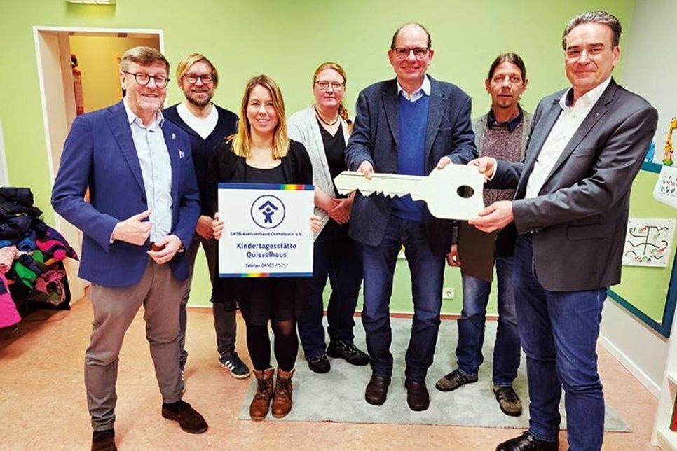 Symbolische Schlüsselübergabe (von links): Bürgermeister Sven Patheil-Böhnke, Fachbereichsleiter Michèl Soltmann (Gemeinde Timmendorfer Strand), die neue Kita-Leiterin Sina Kamp, Maike Vogler, Martin Liegmann und Matthias Thoms vom Kinderschutzbund sowie Hendrik Meyer von der Perspektive Bildung freuen sich über die Übergabe der Trägerschaft des Quieselhauses an den Kinderschutzbund.