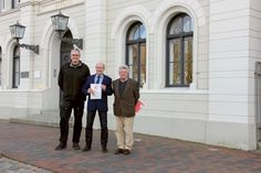 Bauamtsleiter Stefan Gabriel und Bürgermeister Martin Voigt nehmen mit der Denkmalplakette des Landes Schleswig-Holstein eine besondere Auszeichnung aus den Händen von Landeskonservator Dr. Michael Paarmann entgegen.