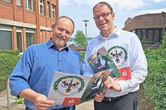 Helge Wiederich (links) und Torben Martens werfen einen zufriedenen Blick in die Gildezeitung 2024. Auf dem Titelblatt thront das Königspaar Klaus III. und Ute I. Stänner.