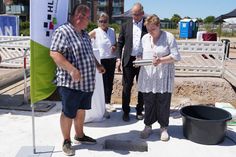 Ehemaliges Wohnbeiratsmitglied Oliver Jansen, Geschäftsführerin der Stiftung Leben und Wohnen (Bauherrin), Katrin Koch, Geschäftsführer HLW Leben und Wohnen gGmbH (Betreiber) Carsten Krüger und Jil Paulina Heintz (v.lks.) aus der Wohngruppe 6 des KSH Merkendorf versenkten die Zeitkapsel, in die es auch eine aktuelle Ausgabe des reporters geschafft hat.