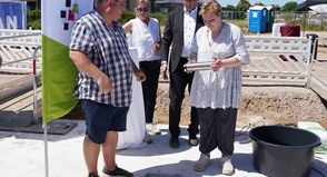 Ehemaliges Wohnbeiratsmitglied Oliver Jansen, Geschäftsführerin der Stiftung Leben und Wohnen (Bauherrin), Katrin Koch, Geschäftsführer HLW Leben und Wohnen gGmbH (Betreiber) Carsten Krüger und Jil Paulina Heintz (v.lks.) aus der Wohngruppe 6 des KSH Merkendorf versenkten die Zeitkapsel, in die es auch eine aktuelle Ausgabe des reporters geschafft hat.