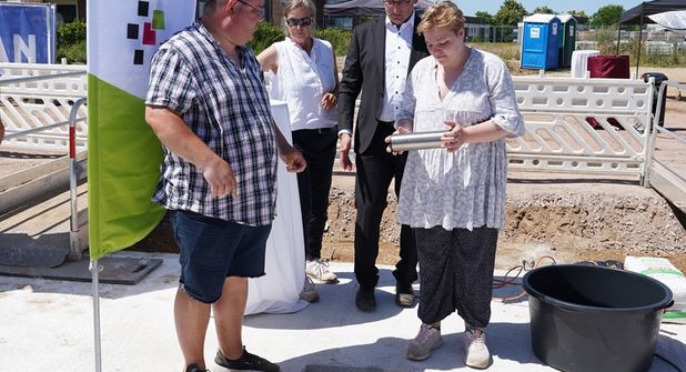 Ehemaliges Wohnbeiratsmitglied Oliver Jansen, Geschäftsführerin der Stiftung Leben und Wohnen (Bauherrin), Katrin Koch, Geschäftsführer HLW Leben und Wohnen gGmbH (Betreiber) Carsten Krüger und Jil Paulina Heintz (v.lks.) aus der Wohngruppe 6 des KSH Merkendorf versenkten die Zeitkapsel, in die es auch eine aktuelle Ausgabe des reporters geschafft hat.