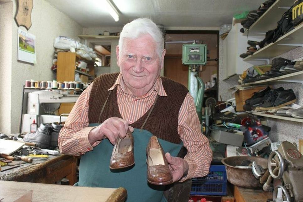 Emil Martin in seiner Werkstatt mit seinem Meisterstück (Leder-Damenschuhe) von 1958.