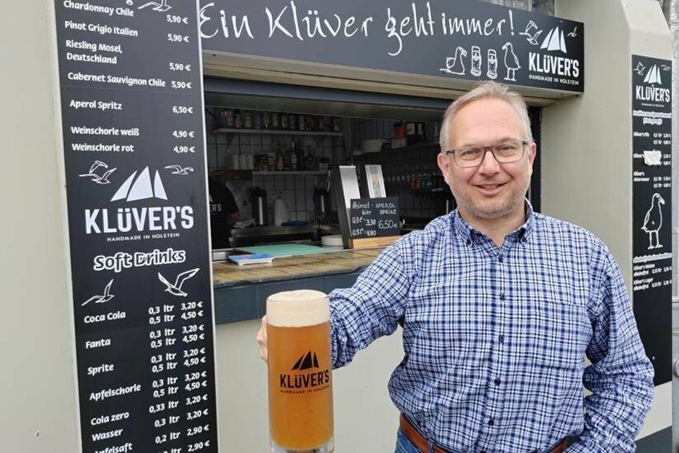Inhaber Olaf Klüver mit einem frisch gezapften „Klüver‘s“-Bier vor der Hafenräucherei in Niendorf/Ostsee.