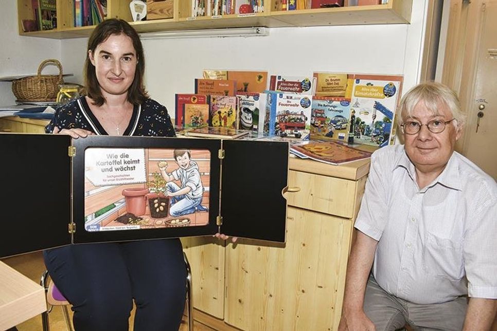 Mirena Günther, Assistenz der Geschäftsführung der Stiftung, und Stiftungs-Geschäftsführer Jörg Schumacher zeigen hier die Bilderbücher und das Kamishibai (Erzähltheater mit verschiedenen Bildtafeln).
