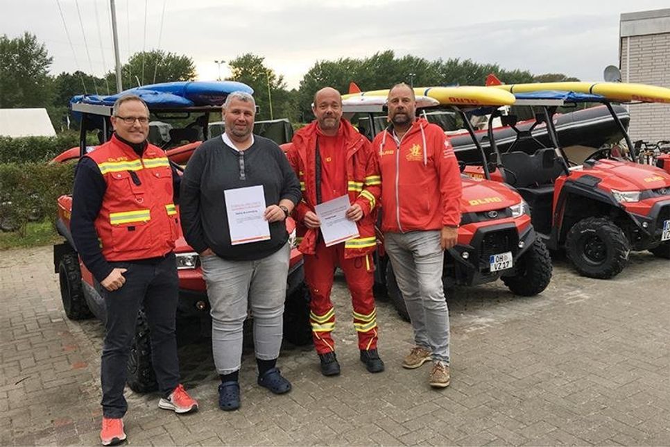 DLRG-Abschnittsleiter Peter Franz (rechts) und Klaus Holger Hecken (Einsatzleiter Küste Schleswig-Holstein) nehmen die Jubilare Helge Kajak (2.v.re.) und Martin Brandenburg in ihre Mitte. (Foto: Franziska Sofia Hildner/hfr)
