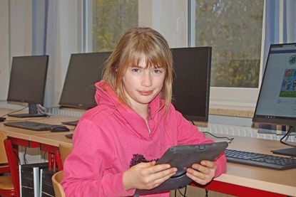 Laura ist sich noch nicht so sicher, was sie mit dem Tablet anfangen soll.