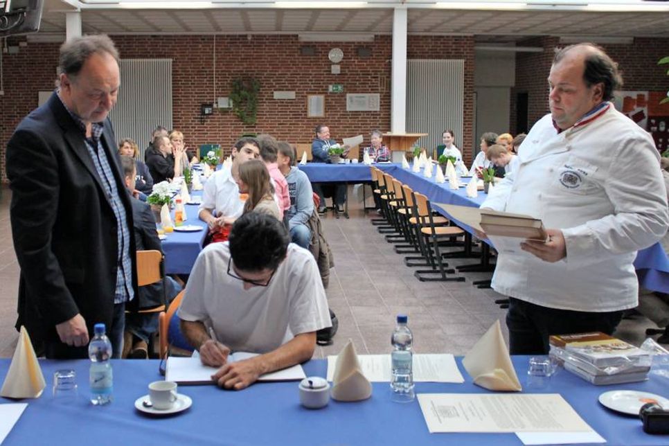 Die Auszubildenden schrieben sich unter Beisein von Lehrmeister Hartmut Masurek (lks.) und stellvertretendem Obermeister Helmut Börke in das „Goldene Buch“ der Bäcker-Innung ein.